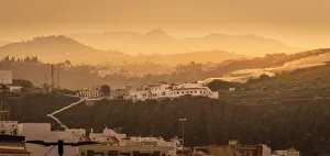 View of hillside houses and mountains at sunset near El Pagador, Las Palmas, Gran Canaria, Canary Islands, Spain View of hillside houses and mountains at sunset near El Pagador, Las Palmas, Gran Canaria, Canary Islands, Spain