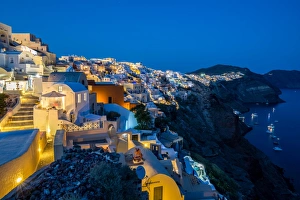 The view from Oia castle along Santorinis caldera during the evening blue hour with The view from Oia castle along Santorinis caldera during the evening blue hour with