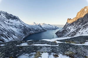 Top view of snowy peaks and frozen sea of the Ornfjorden surrounding the village of Fjordgard Top view of snowy peaks and frozen sea of the Ornfjorden surrounding the village of Fjordgard