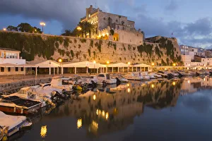 View across tranquil harbour to the illuminated Town Hall at dusk, Ciutadella (Ciudadela) View across tranquil harbour to the illuminated Town Hall at dusk, Ciutadella (Ciudadela)