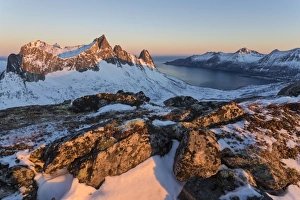 View of the village of Husoy and icy sea along the Oyfjorden from peak Hesten at dawn View of the village of Husoy and icy sea along the Oyfjorden from peak Hesten at dawn