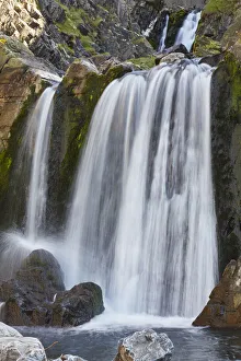 A waterfall cascades down a gorge cut into coastal cliffs, at Spekes Mill Mouth A waterfall cascades down a gorge cut into coastal cliffs, at Spekes Mill Mouth