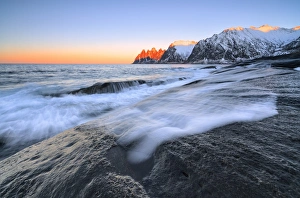 The waves of the icy sea crashing on the rocky cliffs at dawn Tungeneset, Senja, Troms county The waves of the icy sea crashing on the rocky cliffs at dawn Tungeneset, Senja, Troms county