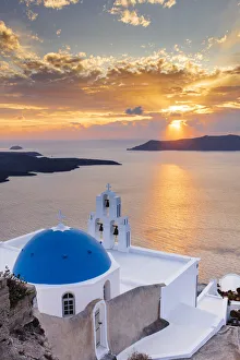 A white church with blue dome overlooking the Aegean Sea at sunset, Santorini, Cyclades, Greek Islands, Greece, Europe A white church with blue dome overlooking the Aegean Sea at sunset, Santorini, Cyclades, Greek Islands, Greece, Europe