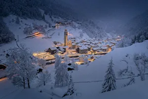 Winter dusk over the illuminated village in deep snow, Gerola Alta, Valgerola Winter dusk over the illuminated village in deep snow, Gerola Alta, Valgerola
