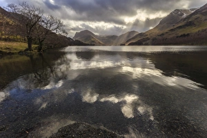 Winter reflections, shafts of sunlight break through clouds, Buttermere, Lake District Winter reflections, shafts of sunlight break through clouds, Buttermere, Lake District