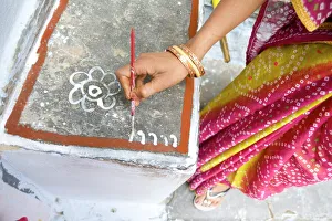 Woman painting her doorstep with rice flour paste, making rangoli design Diwali Festival Woman painting her doorstep with rice flour paste, making rangoli design Diwali Festival
