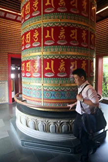 Worshipper and Viarocana Buddhist prayer wheel, Buddha Tooth Relic Temple in Chinatown Worshipper and Viarocana Buddhist prayer wheel, Buddha Tooth Relic Temple in Chinatown