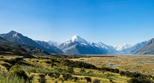 Yellow grass field with large mountains in the distance, South Island, New Zealand Yellow grass field with large mountains in the distance, South Island, New Zealand
