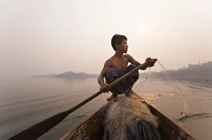 A young man pulls in his nets at the end of the day on Indawgyi Lake, Kachin State A young man pulls in his nets at the end of the day on Indawgyi Lake, Kachin State