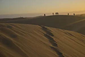 Young people watching the sunset at Maspalomas sand dunes, near Playa de los Ingleses, Gran Canaria, Canary Islands Young people watching the sunset at Maspalomas sand dunes, near Playa de los Ingleses, Gran Canaria, Canary Islands
