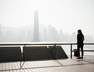 Young woman standing on Tsim Sha Tsui Waterfront, Kowloon, Hong Kong, China, Asia Young woman standing on Tsim Sha Tsui Waterfront, Kowloon, Hong Kong, China, Asia