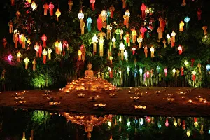 Lanterns and candles reflected in a pool with a Buddha stature for the Loy Krathong Festival at Wat Phan Tao Temple in Lanterns and candles reflected in a pool with a Buddha stature for the Loy Krathong Festival at Wat Phan Tao Temple in