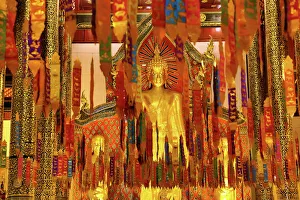 New Year banners and gold Buddha statue inside the Wat Chedi Luang Temple during Songkran in Chiang Mai, Thailand New Year banners and gold Buddha statue inside the Wat Chedi Luang Temple during Songkran in Chiang Mai, Thailand