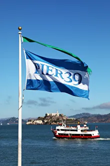 Pier 39 flag, sightseeing boat and Alcatraz prison island in San Franciso, California Pier 39 flag, sightseeing boat and Alcatraz prison island in San Franciso, California