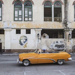 50s Classic American car passing a mural of Che Guevara, Habana Vieja, Havana, Cuba 50s Classic American car passing a mural of Che Guevara, Habana Vieja, Havana, Cuba