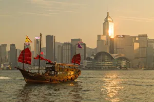 Aqua Luna junk boat and Hong Kong Island skyline at sunset, Hong Kong, China Aqua Luna junk boat and Hong Kong Island skyline at sunset, Hong Kong, China