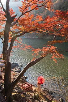 Arashiyama, Kyoto, Kyoto prefecture, Kansai region, Japan. Woman with red umbrella Arashiyama, Kyoto, Kyoto prefecture, Kansai region, Japan. Woman with red umbrella