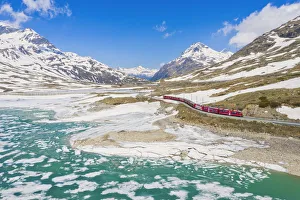 Bernina Express train at Lago Bianco during thaw, Bernina Pass, canton of Graubunden Bernina Express train at Lago Bianco during thaw, Bernina Pass, canton of Graubunden
