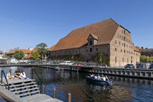 A boat passes a converted warehouse on a canal near the city centre, Copenhagen, Zealand A boat passes a converted warehouse on a canal near the city centre, Copenhagen, Zealand