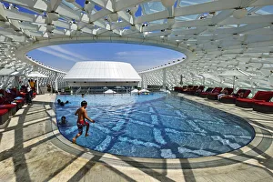 A boy jumps into the swimming pool of the Yas Marina Circuit Formula 1 race track A boy jumps into the swimming pool of the Yas Marina Circuit Formula 1 race track