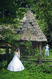 Bride stood in front of a traditional thatched roof Bride stood in front of a traditional thatched roof