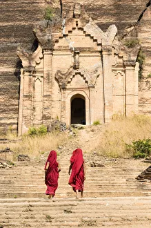 Buddhist novice monks walking by the Mingun Pahtodawgyi, unfinished monument stupa Buddhist novice monks walking by the Mingun Pahtodawgyi, unfinished monument stupa