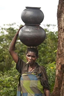 Burundi. A woman uses traditional pots to transport her goods to market Burundi. A woman uses traditional pots to transport her goods to market