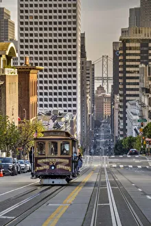 Cable car crossing California Street with Bay Bridge backdrop, San Francisco, California, USA Cable car crossing California Street with Bay Bridge backdrop, San Francisco, California, USA