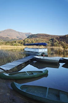 Cape Floral Region Protected Areas Collection: Canoes on lake with Drakensberg mountains in background, Ukhahlamba-Drakensberg Park