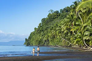 Central America, Costa Rica, Golfito, a young couple on a black sand beach in Piedras Central America, Costa Rica, Golfito, a young couple on a black sand beach in Piedras