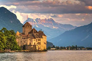 Chillon Castle (Chateau de Chillon) on shores of Lake Geneva with the Alps in background Chillon Castle (Chateau de Chillon) on shores of Lake Geneva with the Alps in background
