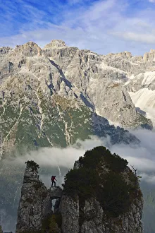 Climber on a rock tower of the Croda Rossa overlooking the Dreischusterspitze, Alta Climber on a rock tower of the Croda Rossa overlooking the Dreischusterspitze, Alta