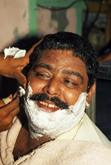 Prints of A close shave: most men in Pakistan visit a barber several times each week Pakistan Prints: A Close Shave: Pakistan Print