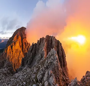 Cloudy sunset with Roda de Vael peak illuminated and backlight red clouds from the rocks Cloudy sunset with Roda de Vael peak illuminated and backlight red clouds from the rocks
