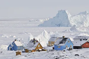 Colourful row of houses with icebergs in the background, Qeqertarsuaq, Disko Island Colourful row of houses with icebergs in the background, Qeqertarsuaq, Disko Island