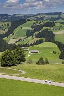 Convertible car on winding road in the Emmental Valley, Berner Oberland, Switzerland Convertible car on winding road in the Emmental Valley, Berner Oberland, Switzerland