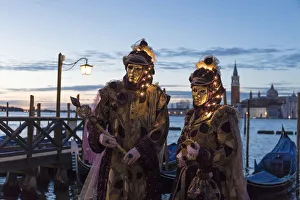 Couple with illuminated masks at Carnival time, Piazza San Marco (St. Marks Square) Couple with illuminated masks at Carnival time, Piazza San Marco (St. Marks Square)