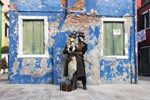 Couple in steampunk costumes in front of old blue house at Carnival time, Burano Island Couple in steampunk costumes in front of old blue house at Carnival time, Burano Island