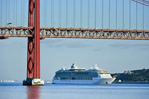 A cruise ship in the Tagus river, leaving the port of Lisbon, passes beneath the 25 A cruise ship in the Tagus river, leaving the port of Lisbon, passes beneath the 25