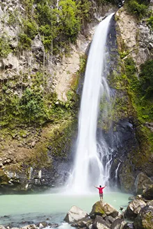 Dominica, Delices. A man stands at the base of Victoria Falls, one of the tallest Dominica, Delices. A man stands at the base of Victoria Falls, one of the tallest