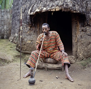 A Dorze man sits outside his home smoking locally-grown A Dorze man sits outside his home smoking locally-grown