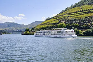 A Douro river cruise ship passing along the village of Pinhao A Douro river cruise ship passing along the village of Pinhao