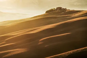 Farmhouse on top of a hill at sunrise in Tuscany, Italy Farmhouse on top of a hill at sunrise in Tuscany, Italy