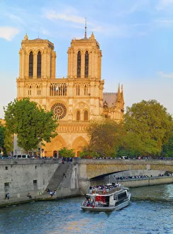 France, Paris, Notre Dame Cathedral and tourist boat on River Seine at sunset France, Paris, Notre Dame Cathedral and tourist boat on River Seine at sunset