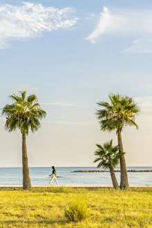 A girl walking along Palm Beach in Larnaca, Cyprus A girl walking along Palm Beach in Larnaca, Cyprus