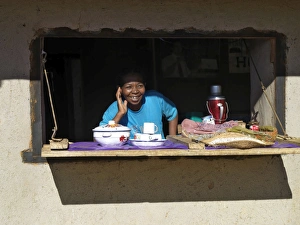 A happy Malagasy woman at the counter of her small A happy Malagasy woman at the counter of her small