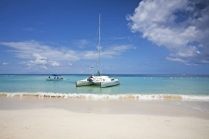Honduras, Bay Islands, Roatan, West Bay, Man reading book on catamaran Honduras, Bay Islands, Roatan, West Bay, Man reading book on catamaran