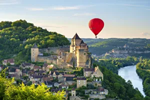 Hot-air balloon over Chateau de Castelnaud castle and Dordogne River valley in late Hot-air balloon over Chateau de Castelnaud castle and Dordogne River valley in late