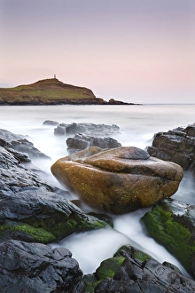 Huge granite boulder lodged on the shores of Porth Ledden at dawn, Cornwall, England Huge granite boulder lodged on the shores of Porth Ledden at dawn, Cornwall, England